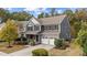 Two-story home with a stone and siding exterior, a well-manicured lawn, and a two-car garage at 3409 Lily Orchard Way, Apex, NC 27539