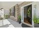 Charming front porch with stone accents, lush potted plants, and an inviting open door at 3409 Lily Orchard Way, Apex, NC 27539