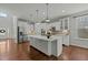 Spacious kitchen boasts white cabinets, stainless steel appliances, large center island and hardwood floors at 3409 Lily Orchard Way, Apex, NC 27539