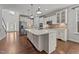 Bright kitchen offers white cabinets, stainless steel appliances, large island and hardwood floors at 3409 Lily Orchard Way, Apex, NC 27539