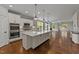 Open kitchen with a large center island, white cabinets, stainless steel appliances, and hardwood flooring at 3409 Lily Orchard Way, Apex, NC 27539