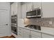 This kitchen has stainless steel microwave, double oven, cooktop, and tiled backsplash with ample storage at 3409 Lily Orchard Way, Apex, NC 27539