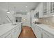 Well-lit kitchen featuring white cabinets, stainless steel appliances, marble countertops and hardwood flooring at 3409 Lily Orchard Way, Apex, NC 27539