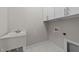 Laundry room featuring a utility sink, storage, and tile flooring at 3409 Lily Orchard Way, Apex, NC 27539