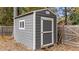 A gray storage shed with white trim and door at 3409 Lily Orchard Way, Apex, NC 27539