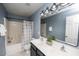 Inviting bathroom featuring a double sink vanity, shower-tub combo, and well-lit mirror at 4011 Volkswalk Pl, Raleigh, NC 27610