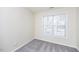 Bright bedroom features a neutral color palette, large window, and plush carpeting at 4011 Volkswalk Pl, Raleigh, NC 27610
