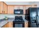 Functional kitchen area featuring a black range, microwave, and refrigerator at 4011 Volkswalk Pl, Raleigh, NC 27610