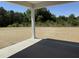 A covered patio offers serene views of the spacious backyard with newly installed sod at 4013 Kingcraig Ln, Zebulon, NC 27597