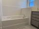 Bright bathroom with white subway tile, white floors, and a white tub under a window at 4013 Kingcraig Ln, Zebulon, NC 27597