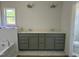 Bathroom with a double vanity, grey cabinets, and a subway-tiled tub at 4013 Kingcraig Ln, Zebulon, NC 27597