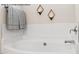 Serene bathroom with a soaking tub, white tile, and decorative sconces for a relaxing retreat at 4013 Kingcraig Ln, Zebulon, NC 27597