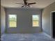 Light and airy bedroom featuring shiplap wall, two windows, and a ceiling fan at 4013 Kingcraig Ln, Zebulon, NC 27597