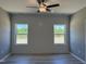 Bedroom with two windows and wood-look floors featuring a ceiling fan with light fixture at 4013 Kingcraig Ln, Zebulon, NC 27597