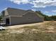 New construction gray home featuring an attached garage and a large backyard, ready for landscaping at 4013 Kingcraig Ln, Zebulon, NC 27597