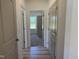 A bright hallway features wood-look floors and doors leading to bedrooms with window views at 4013 Kingcraig Ln, Zebulon, NC 27597