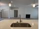 Spacious island sink with a modern faucet, accompanied by an open floor plan with a fireplace at 4013 Kingcraig Ln, Zebulon, NC 27597