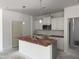 Bright kitchen featuring white cabinets, a stainless steel microwave, and an island with a sink at 4013 Kingcraig Ln, Zebulon, NC 27597