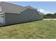 A side yard features fresh, green grass and the home's gray siding and white trim at 4013 Kingcraig Ln, Zebulon, NC 27597