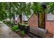 Modern townhome featuring brick and steel exterior with wood porch and landscaped planter at 402 Chavis Way, Raleigh, NC 27601