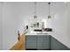 Open-concept kitchen with modern blue cabinetry, white countertops, and stainless steel appliances, flowing into living area at 402 Chavis Way, Raleigh, NC 27601