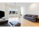 Open-concept living room with hardwood floors, a grey sofa, and large windows at 402 Chavis Way, Raleigh, NC 27601