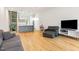 Living room with hardwood floors, grey sofa, and kitchen view at 402 Chavis Way, Raleigh, NC 27601