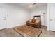 Partially furnished living room features a decorative rug, dark trim mirror, and an inviting brown leather sofa at 402 Chavis Way, Raleigh, NC 27601