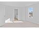 A bedroom with a closed white door, and open bathroom door with natural light streaming in at 41 Alderman Ct # 2, Dunn, NC 28334