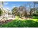 Lush backyard showing the rear of the house with a deck, bordered by mature trees at 4108 4108 Gallatree Ln, Raleigh, NC 27616