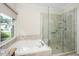 Bright bathroom with a garden tub next to a shower with glass doors and tiled surround at 4108 4108 Gallatree Ln, Raleigh, NC 27616