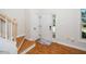Bright entryway with hardwood floors, stairs with white railing, and a front door with sidelight at 4108 4108 Gallatree Ln, Raleigh, NC 27616