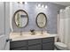 Double sink bathroom with modern fixtures, oval mirrors, and blue patterned wallpaper adding a stylish touch at 4619 Paces Ferry Dr, Durham, NC 27712