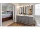 Modern bathroom features a dual sink vanity, decorative wallpaper, and an open doorway to the bedroom at 4619 Paces Ferry Dr, Durham, NC 27712