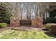 Stone entrance sign for Ashfield Place with manicured landscaping and mature trees in the background at 4619 Paces Ferry Dr, Durham, NC 27712