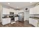 Modern kitchen with stainless steel appliances, white cabinets, and dark countertops at 4619 Paces Ferry Dr, Durham, NC 27712