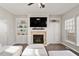 Cozy living room with a fireplace, built-in shelves, and a large flat-screen TV at 4619 Paces Ferry Dr, Durham, NC 27712