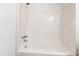 A bathtub and shower combination feature a white tile surround and brushed nickel fixtures at 4633 Edwards Mill Rd, Raleigh, NC 27612