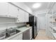 The kitchen features white cabinets, stainless appliances, and a double sink overlooking the backyard at 4633 Edwards Mill Rd, Raleigh, NC 27612