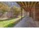 Covered patio overlooking a large backyard with lush greenery and mature trees providing shade at 501 Hiddenbrook Dr, Durham, NC 27703