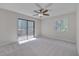 Spacious bedroom with carpet, ceiling fan, sliding glass door to the balcony, and bright light at 501 Hiddenbrook Dr, Durham, NC 27703