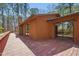A stained wooden deck overlooking a wooded area with glass doors leading to the interior at 501 Hiddenbrook Dr, Durham, NC 27703