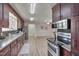 Stylish kitchen with stainless steel appliances, wood cabinets, and access to large living area at 501 Hiddenbrook Dr, Durham, NC 27703