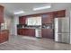 Well lit kitchen with wood cabinets, stainless steel refrigerator, and view of backyard at 501 Hiddenbrook Dr, Durham, NC 27703