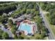 Aerial shot of a community pool and clubhouse featuring red umbrellas, mature trees, and neighborhood streets at 512 Hallburg Ct, Wake Forest, NC 27587