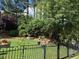 Beautiful fenced backyard featuring lush landscaping, mature trees, and manicured lawn at 512 Hallburg Ct, Wake Forest, NC 27587