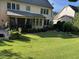 Expansive backyard featuring lush lawn, manicured landscaping, and a patio seating area at 512 Hallburg Ct, Wake Forest, NC 27587
