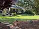 Expansive backyard featuring a lush lawn, mature trees, a patio area, and a charming screened porch at 512 Hallburg Ct, Wake Forest, NC 27587