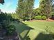 Beautiful backyard featuring a lush green lawn, mature trees, and well-maintained landscaping at 512 Hallburg Ct, Wake Forest, NC 27587