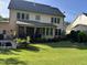 Expansive backyard featuring lush lawn, manicured landscaping, and a patio seating area at 512 Hallburg Ct, Wake Forest, NC 27587